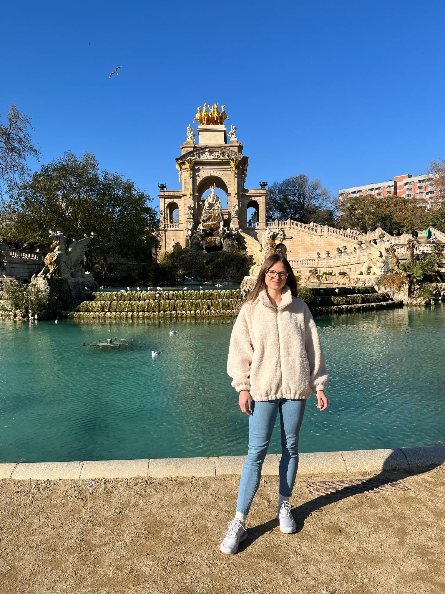Monumentalna fontanna Cascada ze złotą kwadrygą nad turkusowym stawem w Parc de la Ciutadella w Barcelonie