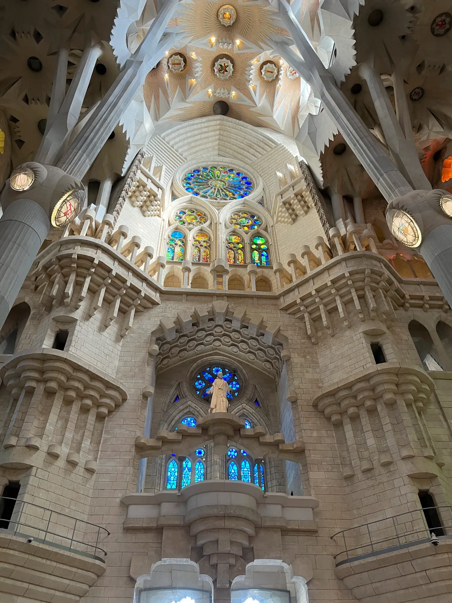 Apsyda Sagrada Família w Barcelonie - posąg świętego, rozeta i sklepienie Gaudiego
