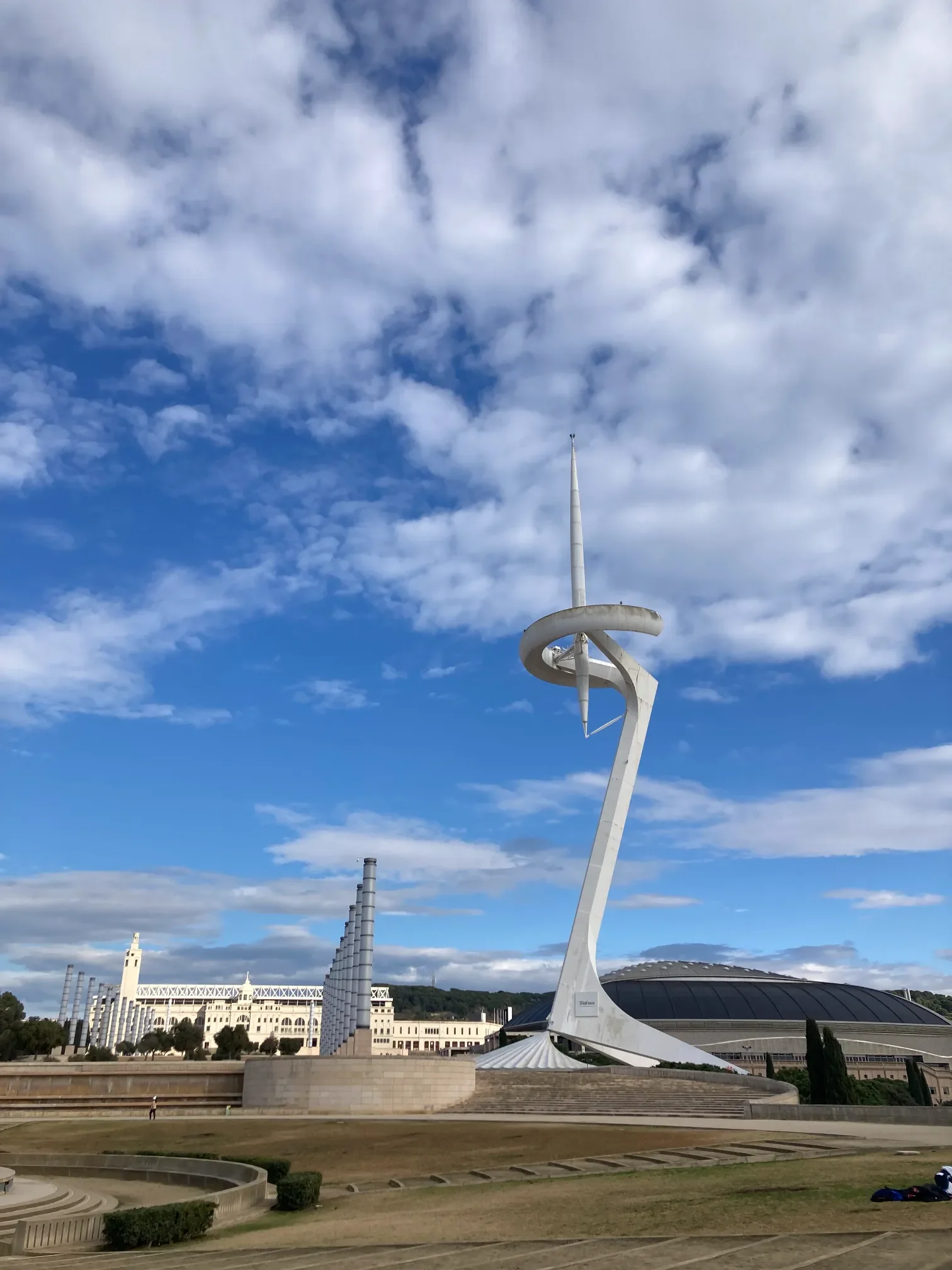 Wieża telekomunikacyjna Calatravy i kompleks olimpijski na wzgórzu Montjuïc w Barcelonie pod pochmurnym niebem