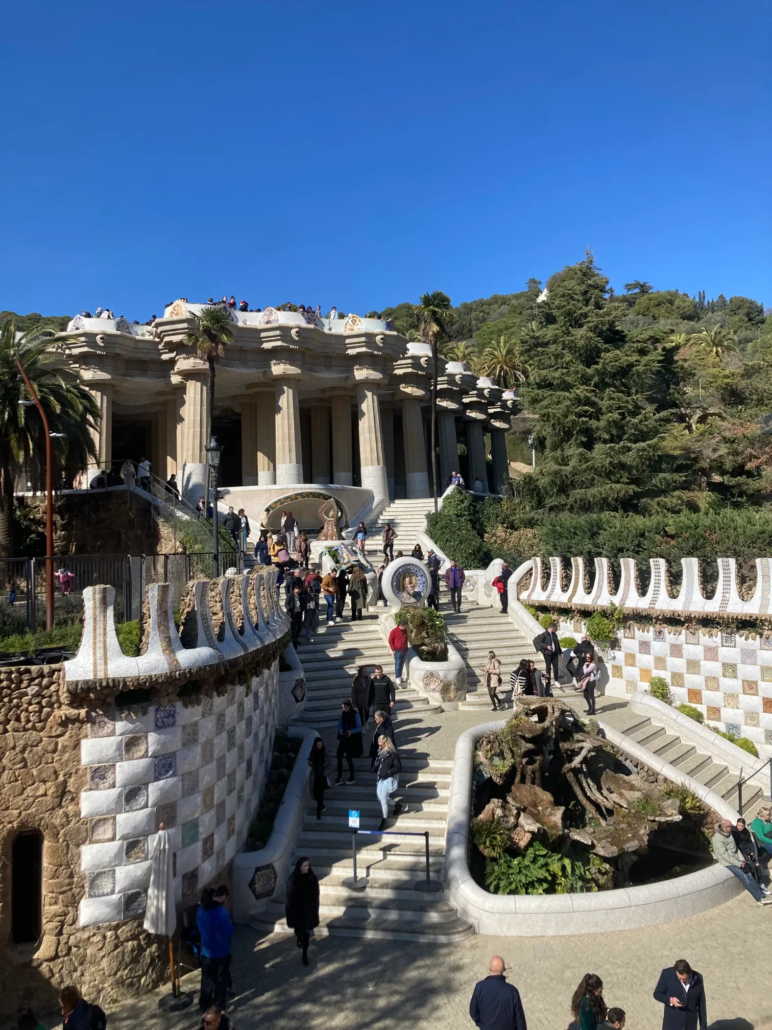 Monumentalne schody Park Güell w Barcelonie prowadzące do sali kolumnowej z mozaikowymi pinaklami Gaudiego