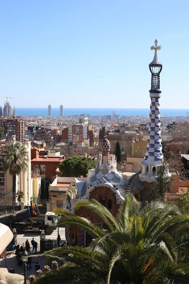 Bajkowy pawilon Gaudiego z mozaikową wieżyczką w Park Güell w Barcelonie na tle panoramy miasta i morza