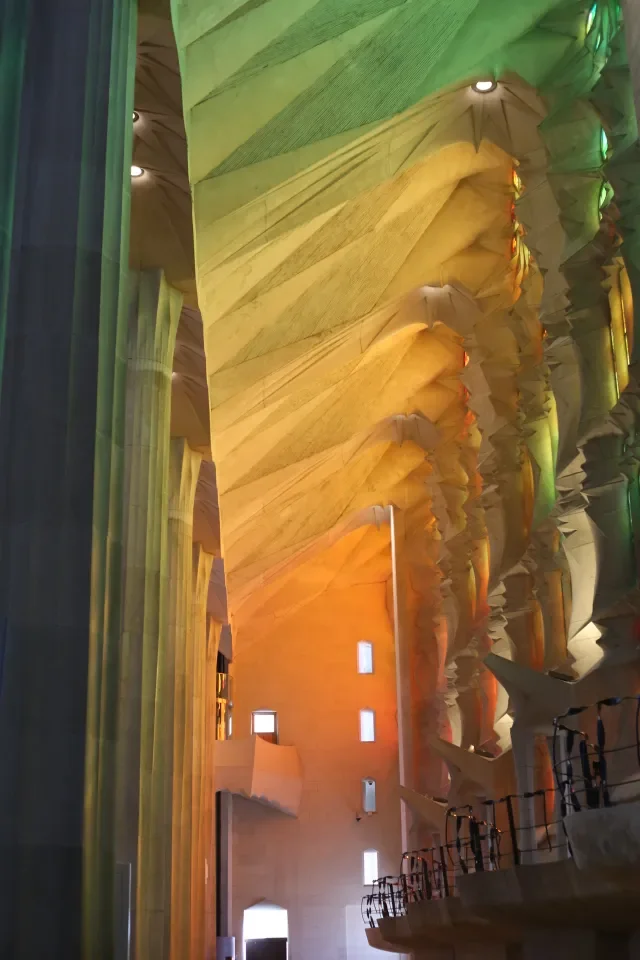 Kolorowe światło witraży oświetlające nawę boczną bazyliki Sagrada Família w Barcelonie