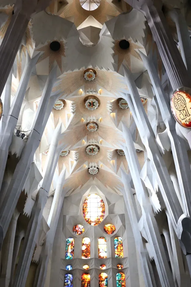 Geometryczne sklepienie wnętrza Sagrada Família w Barcelonie - gałęziaste kolumny i witraże