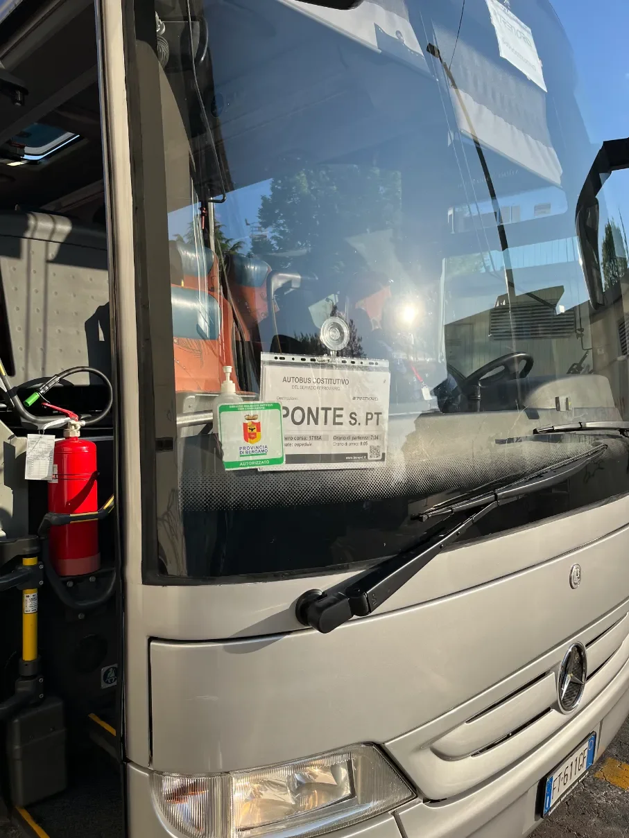 Náhradní autobus Trenord s cedulí Ponte S. Pt za sklem zaparkovaný u nádraží v Bergamu