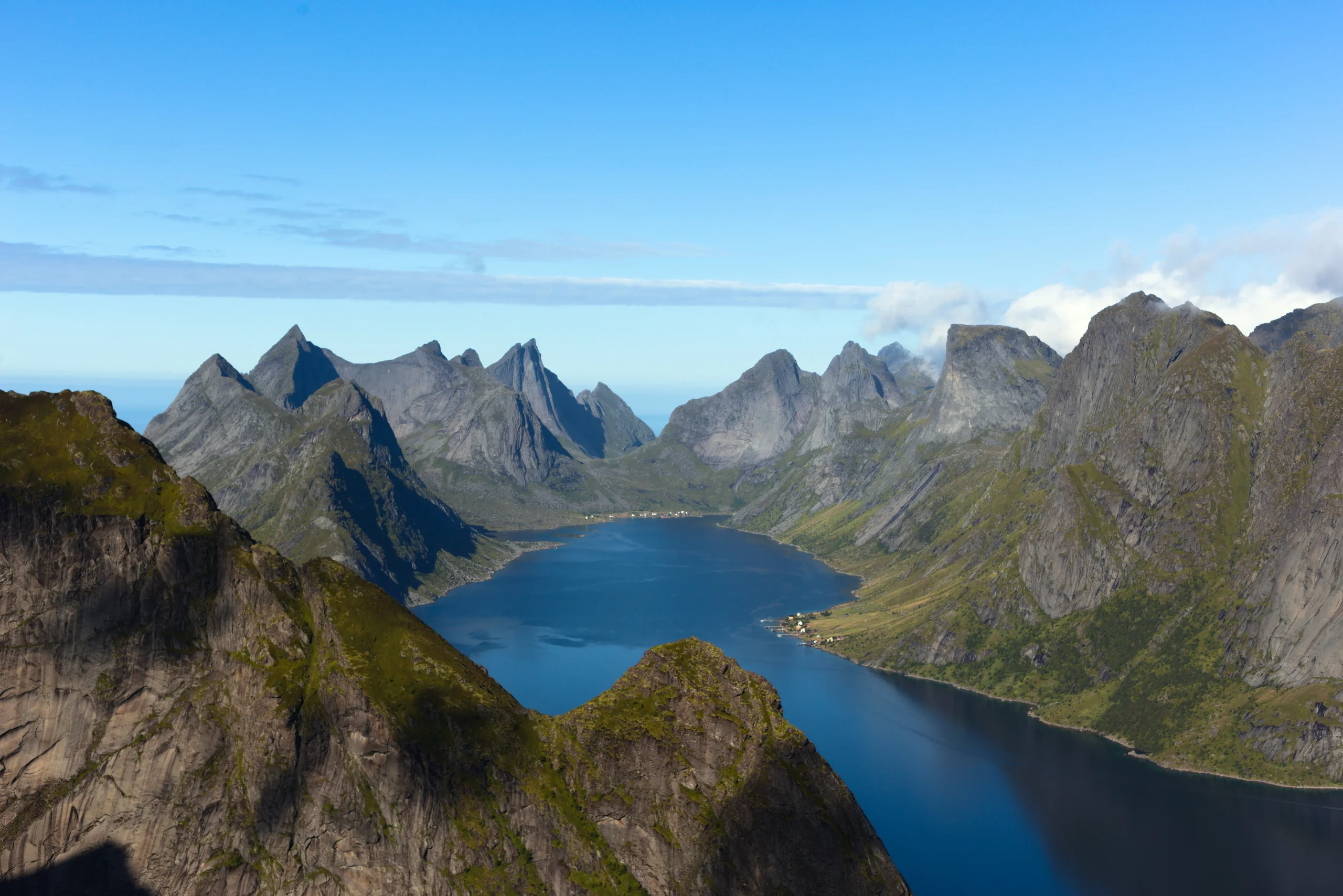Rozeklané žulové vrcholy Lofot obklopující fjord Reinefjorden, výhled z vrcholu Reinebringen v létě