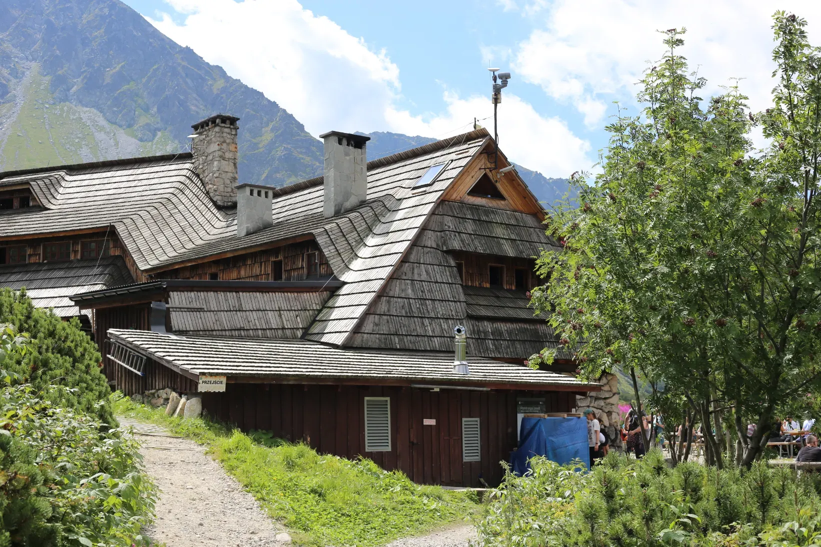 PTTK mountain hut at 1672 m in Dolina Pięciu Stawów valley with a rocky Tatra peak behind