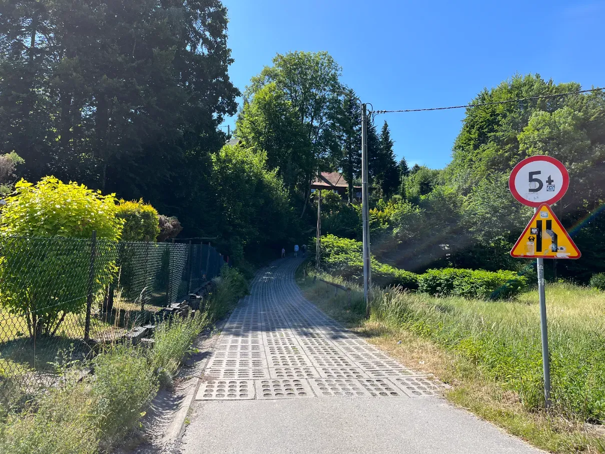Concrete-slab path at the start of the green trail to Skrzyczne in central Szczyrk