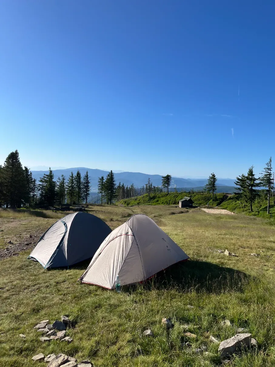 Two camping tents pitched on the meadow near the PTTK shelter on Skrzyczne summit