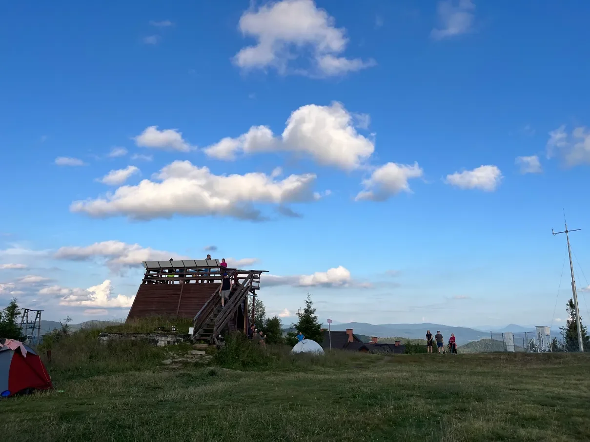 Dřevěná rozhledna na vrcholu Wielké Raczy s turisty a panoramatem Żywieckých Beskyd