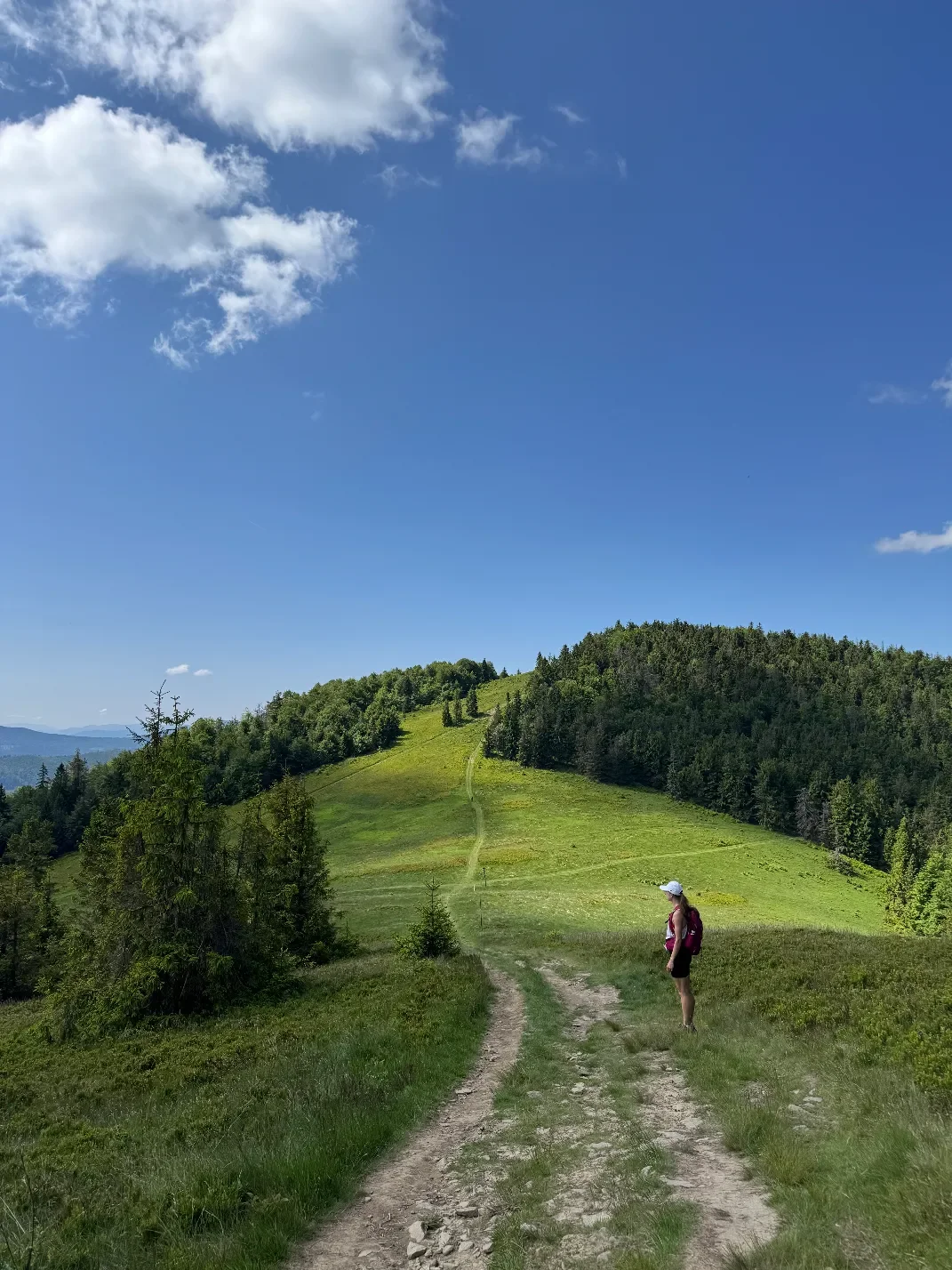 Turista na trase přes louku Przełęczy Halne s výhledem na vrchol Wielké Rycerzowé