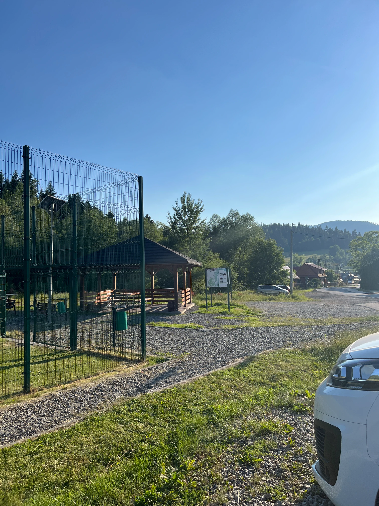 Car park in Glinka next to a sports field and buildings at the start of the trail