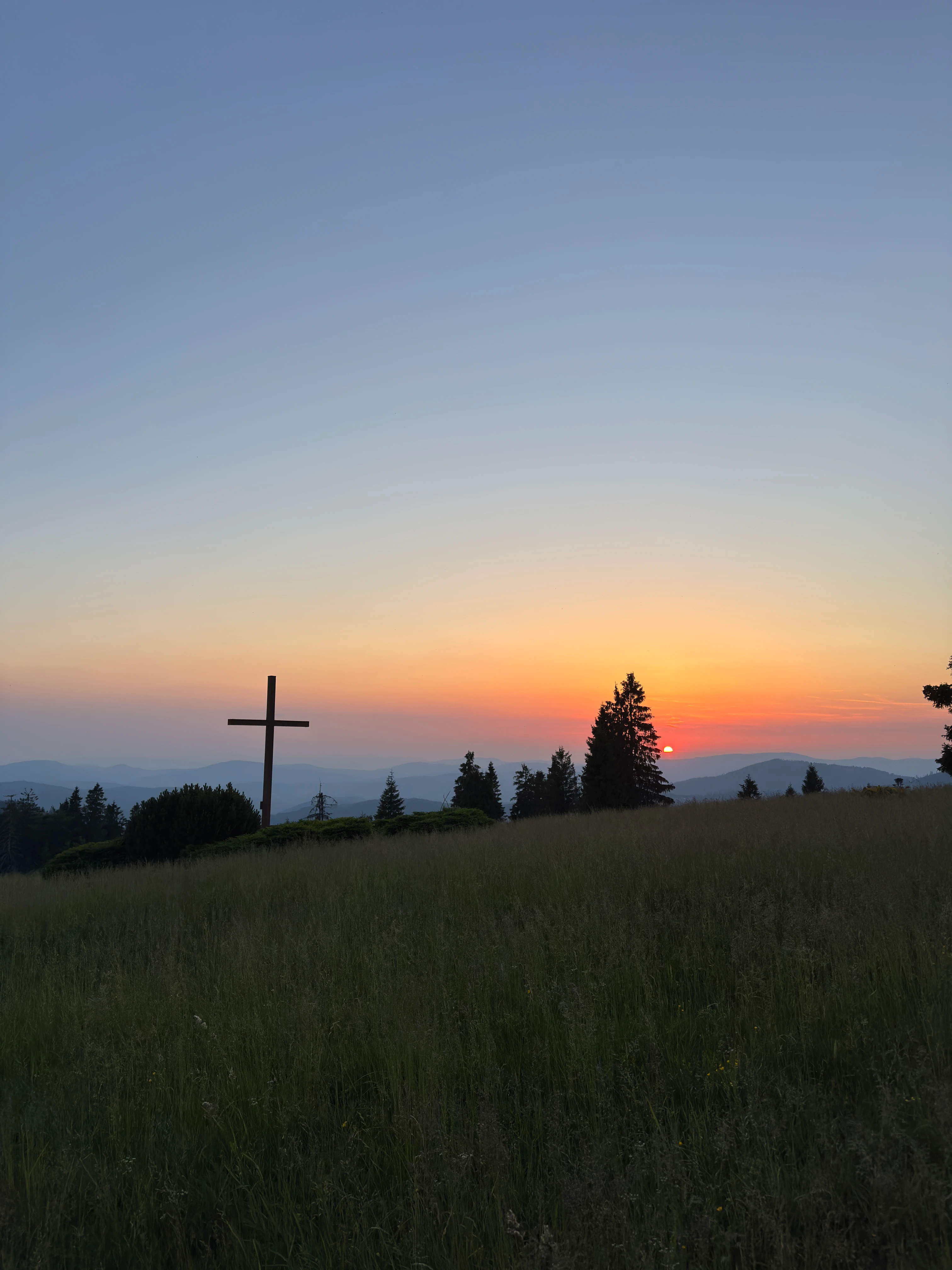 Cross on Hala Krawcula against an orange sunset